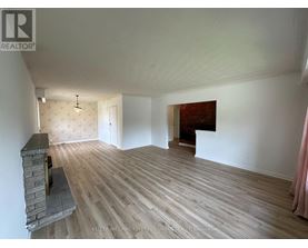 A room with a fireplace and wood flooring.