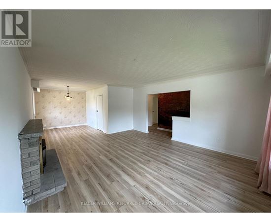 A room with a fireplace and wood flooring.