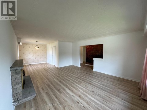 A room with a fireplace and wood flooring.