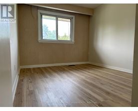 A room with a window and wooden flooring.