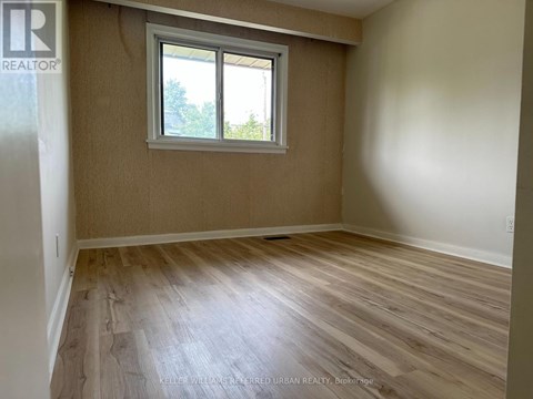 A room with a window and wooden flooring.