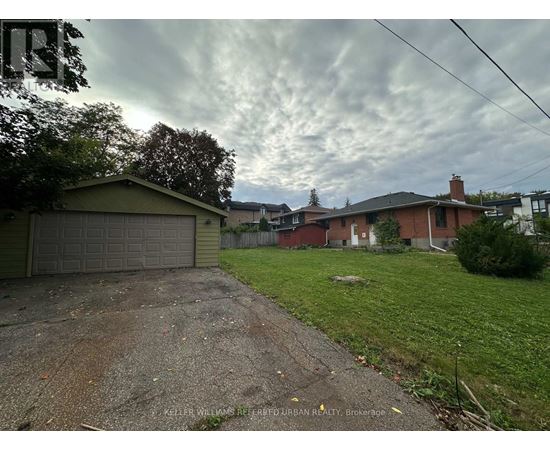 A residential area with houses and a dirt driveway.