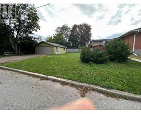 A residential area with a house, garage, and a tree.