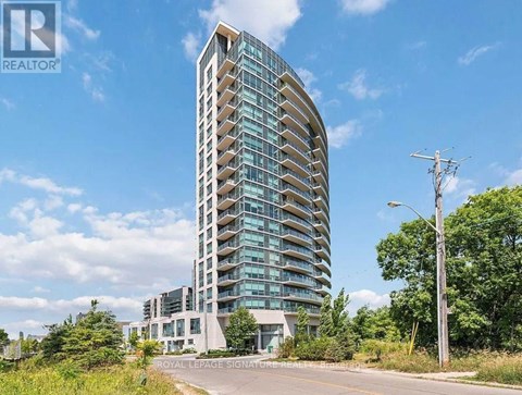 A tall, modern building with a curved facade and balconies on the upper floors.