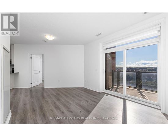 A room with a large window and wooden flooring.