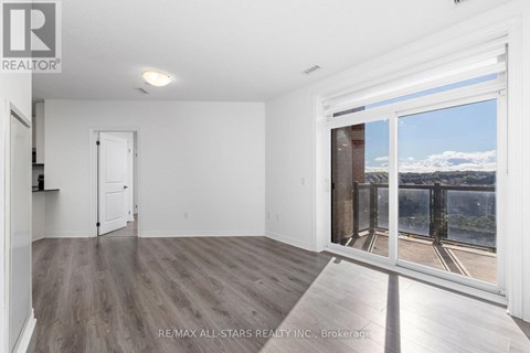 A room with a large window and wooden flooring.