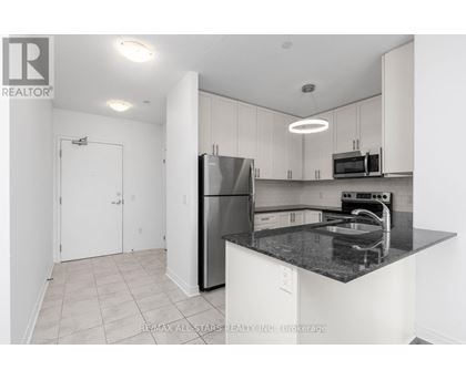 A kitchen with white cabinets and a black countertop.