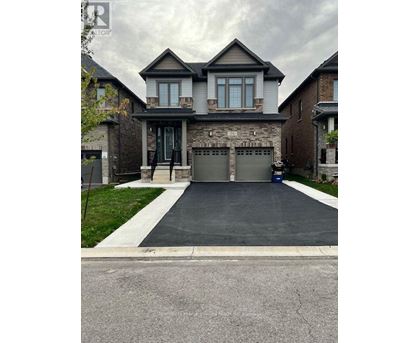 A house with a grey garage door and a driveway.