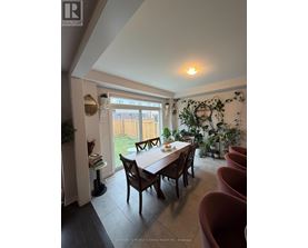 A dining room with a table and chairs.