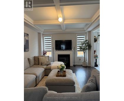 A living room with a grey couch and a fireplace.