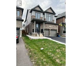 A house with a grey garage door is in front of a house with a brown garage door.