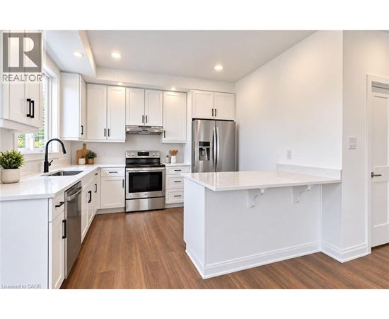 A modern kitchen with white cabinets and stainless steel appliances.