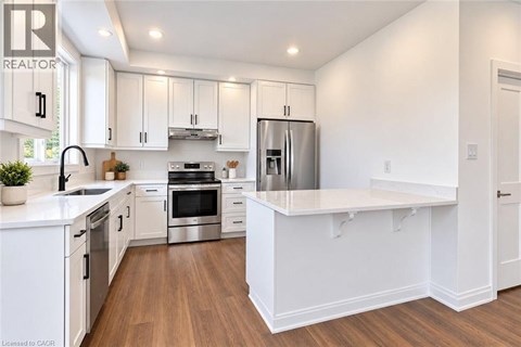 A modern kitchen with white cabinets and stainless steel appliances.