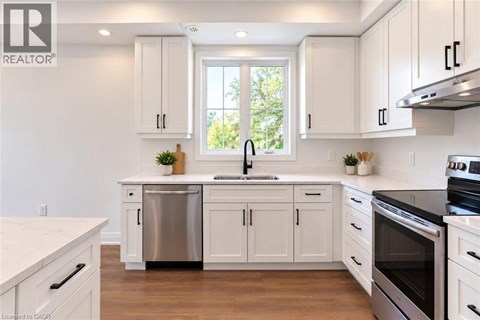 A kitchen with white cabinets and a stainless steel dishwasher.