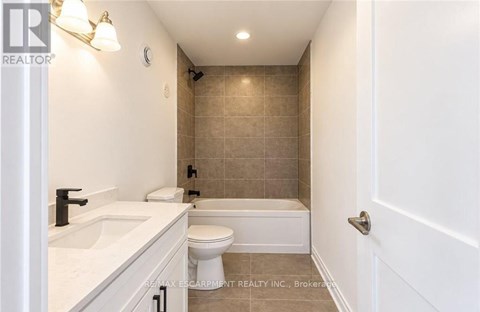 A bathroom with a toilet, sink, and bathtub.