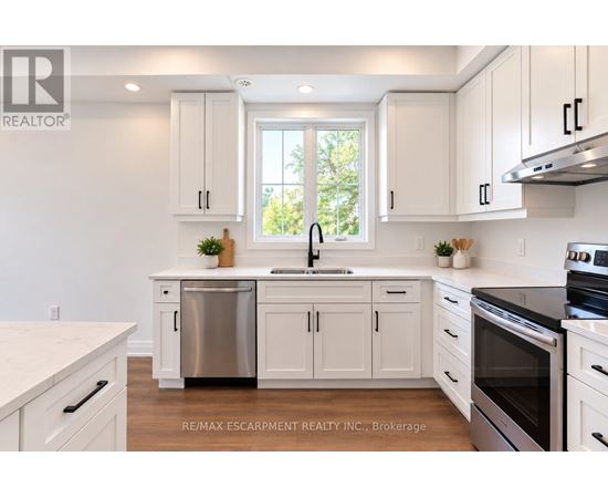 A white kitchen with a window and a sink.