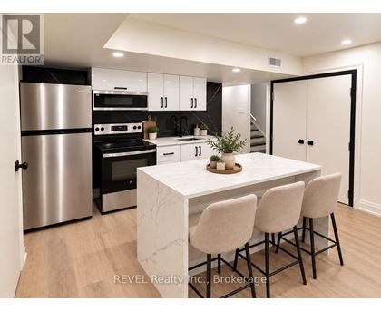 A modern kitchen with a marble table and bar stools.