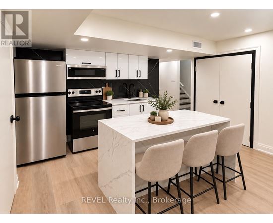 A modern kitchen with a marble table and bar stools.