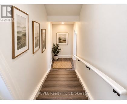 A hallway with a potted plant and pictures on the wall.