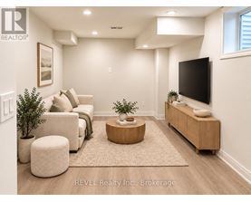 A living room with a couch, a coffee table, and a flat screen TV.