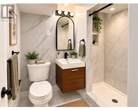 A bathroom with a white toilet and a marble wall.