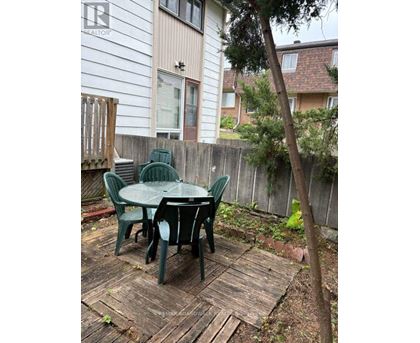 A wooden deck with a green table and chairs.