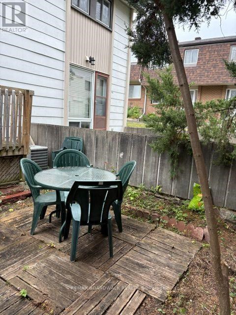 A wooden deck with a green table and chairs.