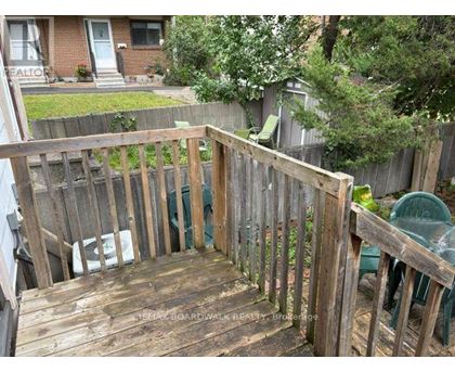 A wooden deck with a green chair and a white bag on it.