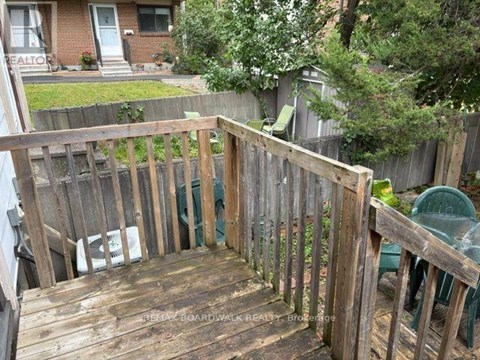 A wooden deck with a green chair and a white bag on it.