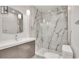 A bathroom with marble wallpaper and a glass shower door.
