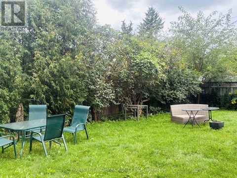 A backyard with a table and chairs and a trampoline.