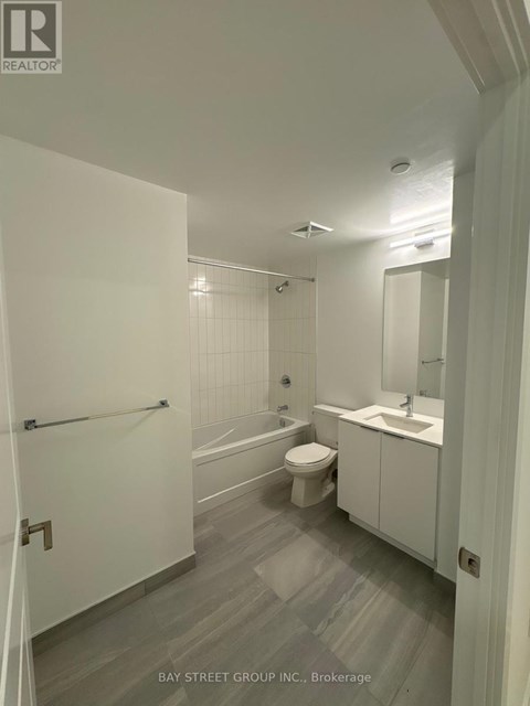 A white bathroom with a toilet, sink, and bathtub.