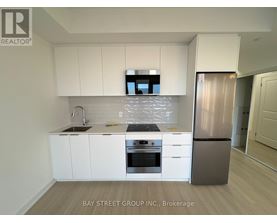 A modern kitchen with white cabinets and stainless steel appliances.