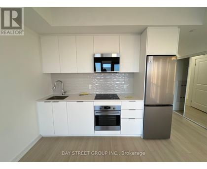 A modern kitchen with white cabinets and stainless steel appliances.
