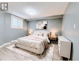 A bedroom with a large bed and a nightstand with a lamp.