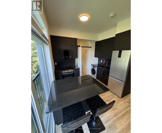 A kitchen with black cabinets and a granite countertop.