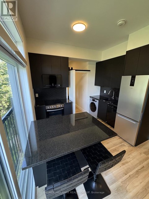 A kitchen with black cabinets and a granite countertop.