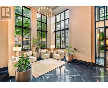 A realtor office with a large window and a plant in a pot.