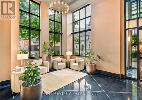 A realtor office with a large window and a plant in a pot.