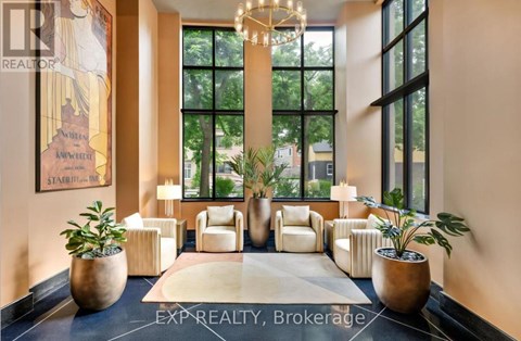 A well-lit, modern living room with a large window and a chandelier.