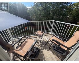 A patio with a table and chairs is set up on a deck.