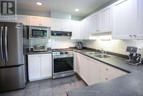 A kitchen with white cabinets and stainless steel appliances.
