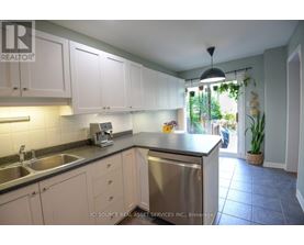 A kitchen with white cabinets and a stainless steel dishwasher.