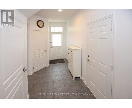A hallway with white doors and a clock on the wall.