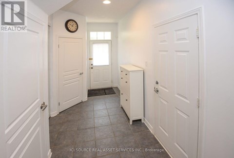 A hallway with white doors and a clock on the wall.