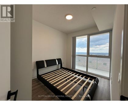A bedroom with a large bed and a view of the outside through the window.