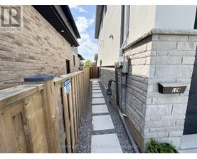 A narrow alleyway between two houses with a sign that says "LOW".