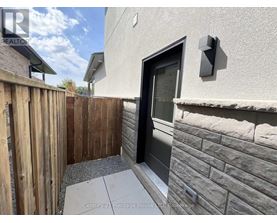 A modern house with a wooden fence and a black door.