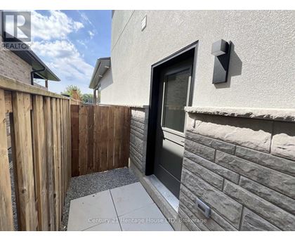 A modern house with a wooden fence and a black door.