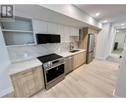 A kitchen with wooden cabinets and a marble countertop.